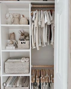 an organized closet with white shelves and wicker baskets