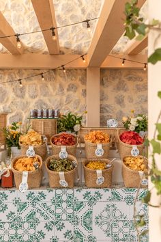 several baskets filled with food sitting on top of a table next to a stone wall