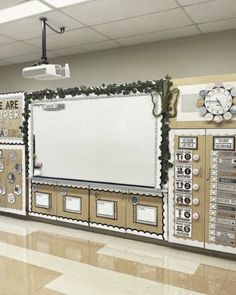 a bulletin board in the middle of a school hallway with decorations on it and an empty whiteboard