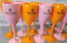 five wine glasses are lined up in a row on yellow bases and pink rims