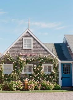 a house covered in flowers with a blue door