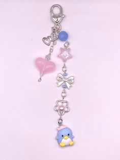 a keychain with an elephant, heart and star charms attached to it on a white background