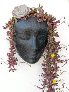 a black head with flowers and plants on it