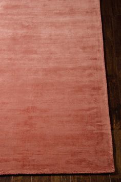 a pink area rug on top of a wooden floor