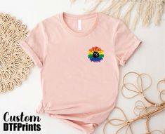 Proud Ally Sunflower Shirt, Rainbow Sunflower Pride T-shirt, LGBTQ+ Support Tee, Floral Pride Gift Tee, Ally Rainbow T-shirt, Flower Pride Flag Tee 🎈HOW TO ORDER 1-) Please, check and review all the photos. 2-) Choose your t-shirt size and color. *Different styles of shirts may have different shades of same color choice due to different manufacturer brands. *For this reason, we recommend you to match shirts from the same styles if you want precisely matching colors (ex. Unisex, V-necks, Toddler, etc.). 3-) Click add to cart. You can go back to add more shirts. 4-)Click "Proceed to check out". 5-)When you check out, you can add a note to seller for any request. 🎈PRODUCT DESCRIPTION UNISEX SHIRTS * Unisex t-shirt fits like a well-loved favorite, featuring a crew neck, and short sleeves, an Pink Crew Neck Top With Rainbow Print, Casual Pink T-shirt With Rainbow Print, Rainbow Graphic Print Shirt With Crew Neck, Multicolor Cotton Shirt For Pride, Casual Rainbow Tops, Crew Neck Cotton Top For Pride, Pride Rainbow Pre-shrunk Top, Crew Neck Top With Screen Print For Pride, Rainbow Print Short Sleeve Shirt