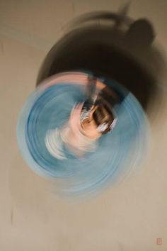 a blurry photo of a man in the middle of a room with a ceiling fan