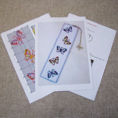 four cross stitch bookmarks with butterflies on them