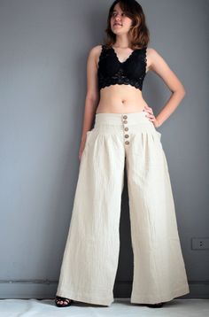 "This 4 size pants is made of 100% cotton fabric. Simple in design, gathered front, with zipper and 5 buttons. Elastic in the back for flexibility. Low waist design. Super cute pocket on both sides feathering fan shape gathering. Long wide leg. Elegant piece.Flattering to most shape. Measurement; S Low waist max 28-36\" Hip max 42\" Length out seam 39\" Length inseam 30\" M Low waist max 36-39\" Hip max 44\" Length out seam 40\" Length inseam 31\" L Low waist max 39-40\" Hip max 46\" Length out Baggy Full-length Pants With Button Closure, Baggy Pants With Button Closure, Beige Summer Pants With Buttons, Summer Beige Pants With Buttons, High Waist Beige Cotton Harem Pants, Beige Cotton Wide Leg Full-length Pants, Beige Cotton Wide Leg Full Length Pants, Beige Cotton Full Length Wide Leg Pants, High-waisted Cotton Wide Leg Pants