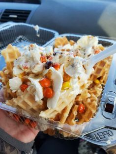 a person holding a plastic container filled with waffles