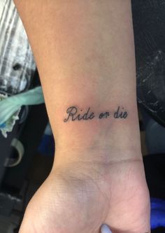 a woman's wrist tattoo with the words ride or die written in cursive font