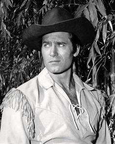 a black and white photo of a man wearing a cowboy hat