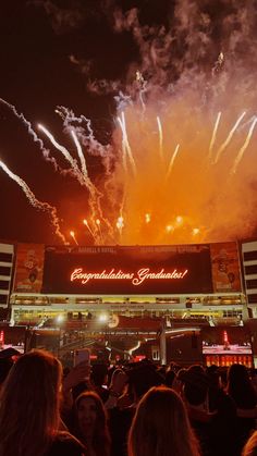 fireworks are lit up in the night sky over a stadium