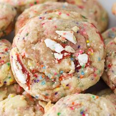 sprinkles and white chocolate chip cookies are piled on top of each other