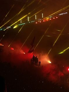 fireworks are lit up in the night sky as people sit on their backs watching them