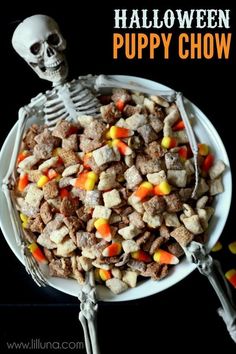 a white plate topped with halloween puppy chow next to candy corn and a skeleton on the side