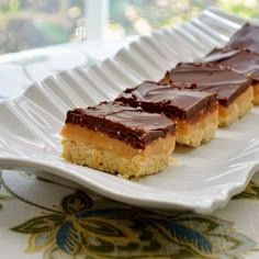 three pieces of chocolate and peanut butter bars on a white plate