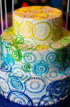 there is a multi layer cake decorated with swirls and icing on the table