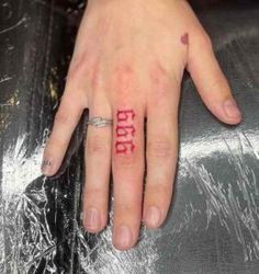 a woman's hand with a ring on it and the word love written in red ink