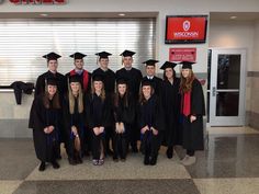 a group of people in graduation caps and gowns posing for a photo at the airport