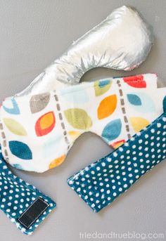 a pair of eye masks sitting on top of a white wall next to a silver foil wrapper