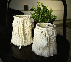 two white vases sitting on top of a black table