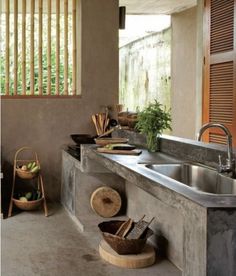 an outdoor kitchen with bamboo blinds and sink