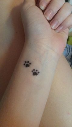 a person with a small paw tattoo on their arm