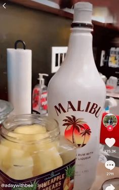 a bottle of mango juice next to a jar of sliced bananas on a counter top