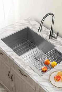 a stainless steel sink in a kitchen with marble counter tops