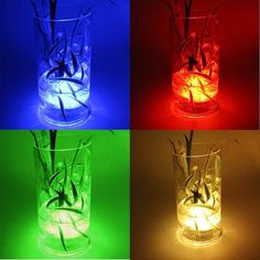 four different colored glass vases with plants in them and one is lit up at the same time