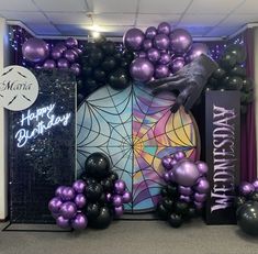 purple and black balloons in front of a birthday backdrop