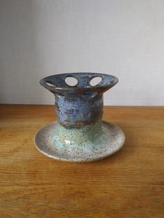 a small blue vase sitting on top of a wooden table