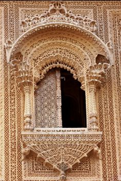 an intricately carved window on the side of a building