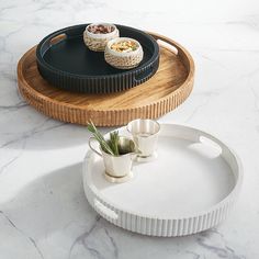 two trays with food on them sitting on a marble table