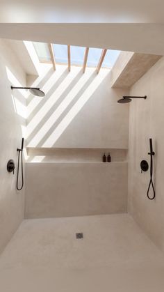 a bathroom with two shower heads and an open skylight