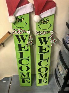 two green wooden welcome signs with santa hats on their heads and the words welcome home