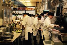 a group of chefs preparing food in a kitchen