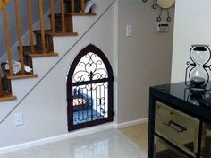 an entry way leading to a staircase with wrought iron railings and glass door on the side