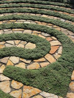 a circular garden design made out of stones and grass