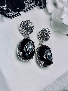 Faux Black Onyx Solid Sterling Silver Earrings Edward Embellished Design#E70e This is a pair of antique-inspired Edwardian style earrings. The flawless oval simulated black onyx gems are surrounded by delicate sterling silver filigree. The lovely full cut oval stones are approximately 14mm x 10mm. In the middle of each earring there lies delicate filigree surrounding a centered inset gem. Please choose white CZ (cubic zirconia), Lab Moissanite, or genuine diamond for the inset gem. The earrings Victorian Style Silver Oval Earrings, Victorian Black Dangle Earrings, Black Oval Vintage Earrings, Victorian Silver Onyx Jewelry, Vintage Black Sterling Silver Earrings, Edwardian Jewelry, Gem Diamonds, Nature Earrings, Onyx Earrings