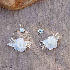 two white flowers are sitting on some gold hoops