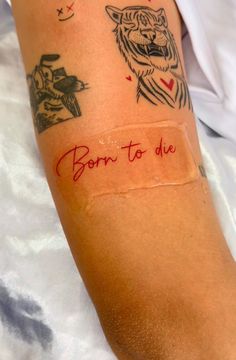 a person with a tattoo on their arm that says born to die, and an image of a tiger