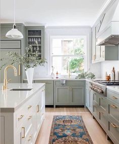 a kitchen with green cabinets, white counter tops and an area rug on the floor