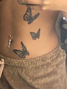 a woman's stomach with three butterflies on her side and the bottom part of her belly