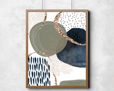 an abstract painting hanging on the wall above a wooden frame with gold and blue accents