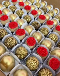 a box filled with cupcakes covered in gold and red frosting next to each other