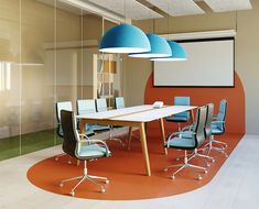 a conference room with blue chairs and a large screen on the wall above it is an orange carpet