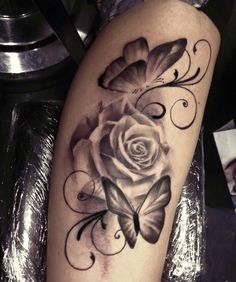 a rose and butterfly tattoo on the leg