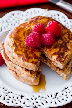 pancakes with raspberries and syrup on a white plate