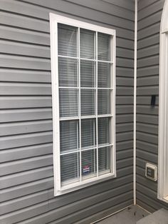 a house that is being painted gray with white trim on the windows and door frame